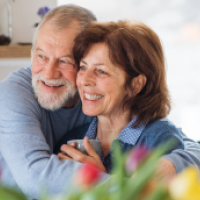 Aged man hugs aged woman