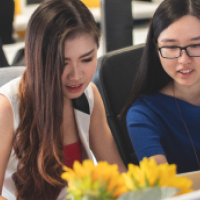 Two asian women are looking at the screen