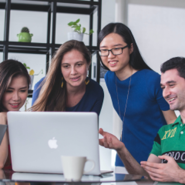 Four young people are looking at laptop screen